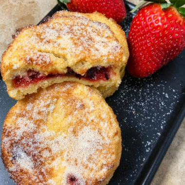 Jam stuffed French toast coated in sugar with raspberry jam showing through the center
