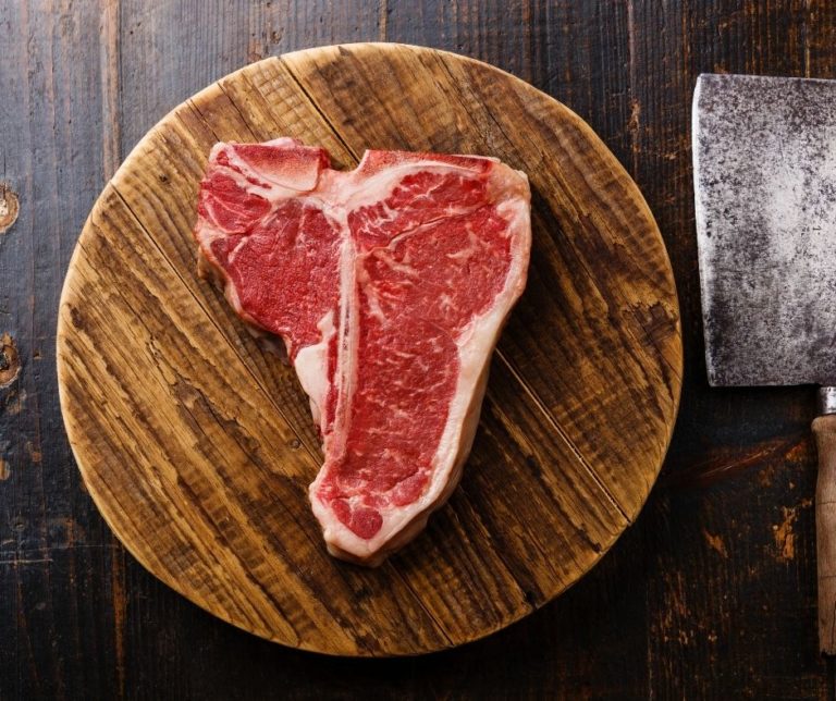 uncooked t bone steak on chopping board