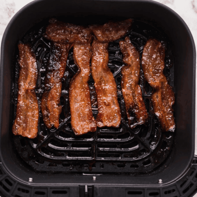 Cooking bacon strips in the air fryer until crispy and golden brown.