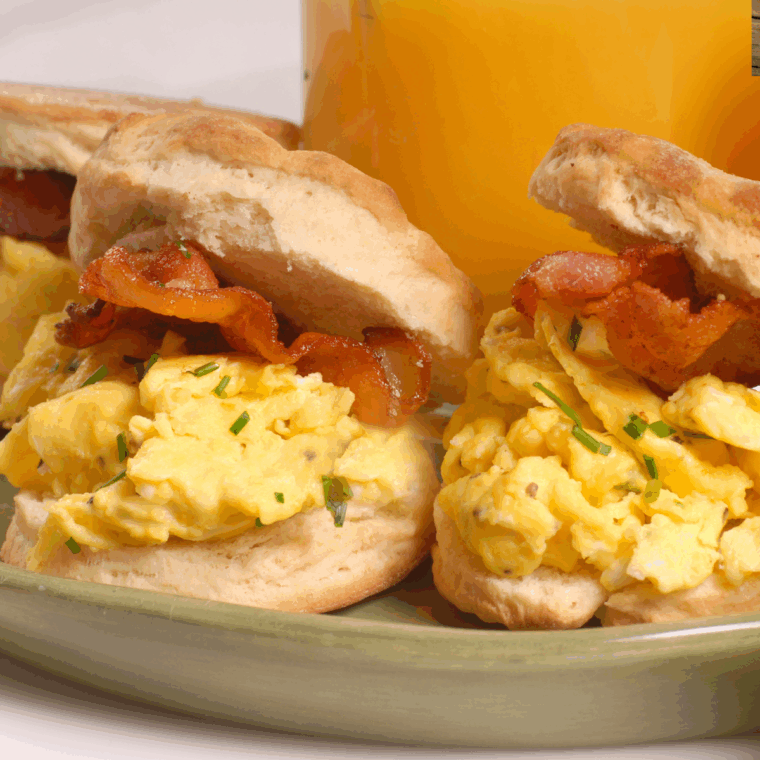 Air fryer breakfast biscuits filled with eggs and crispy bacon, golden and ready to serve.