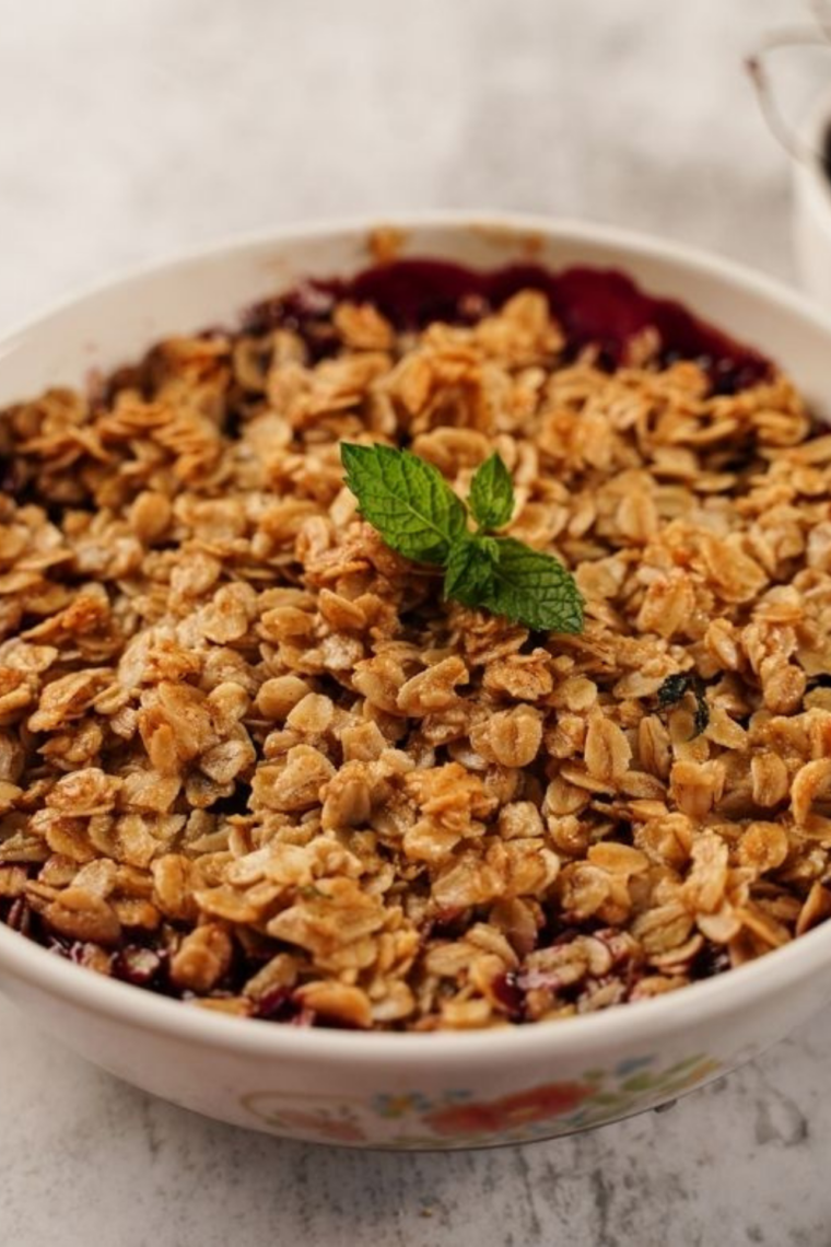 Air fryer cherry crisp in a baking dish with bubbling cherry filling and a golden oat crumble topping, fresh out of the air fryer and ready to serve warm.