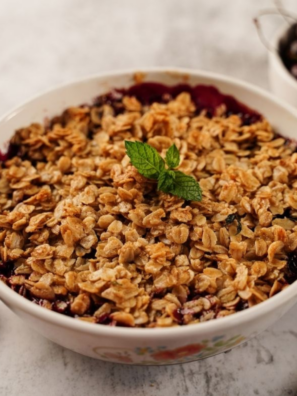 Air fryer cherry crisp in a small dish with golden oat topping and bubbling cherry filling
