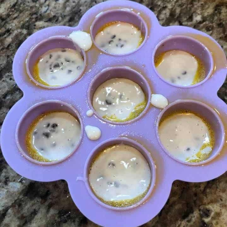 Spoonfuls of pancake batter placed in silicone molds for Air Fryer Chocolate Chip Pancake Bites, ready for the air fryer.