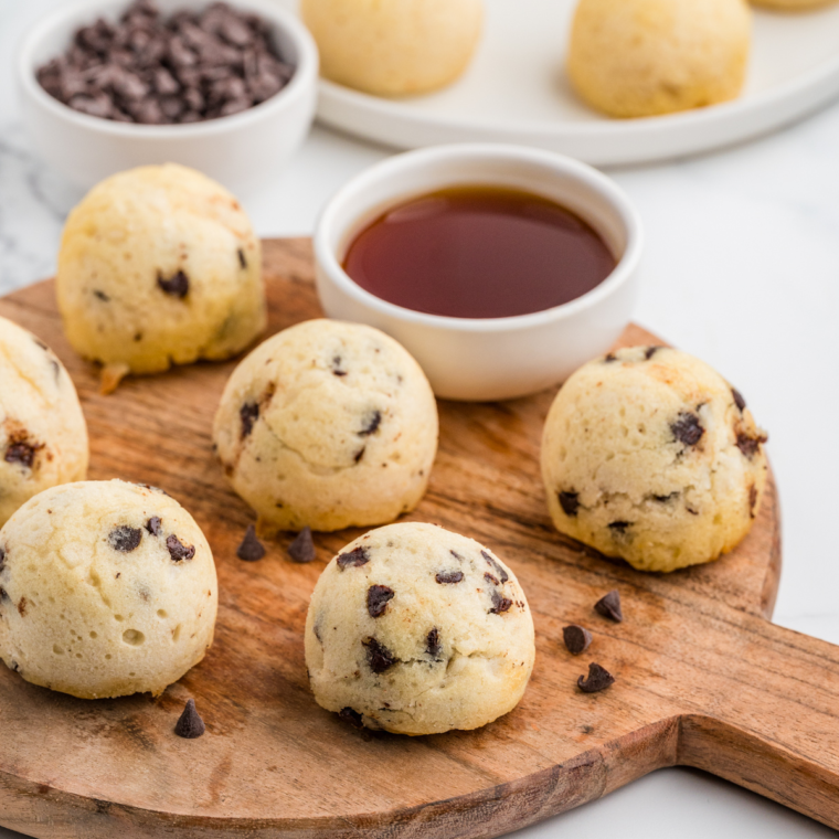 Plated Air Fryer Chocolate Chip Pancake Bites drizzled with maple syrup and topped with fresh berries.