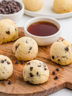 A plate of golden-brown air fryer chocolate chip pancake bites, drizzled with syrup and topped with chocolate chips, ready to be enjoyed as a delicious breakfast treat.