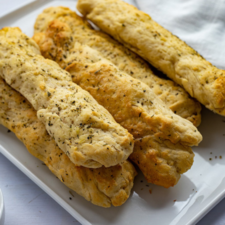 Plate of Air Fryer Copycat Olive Garden Breadsticks, golden and perfectly baked with a buttery garlic topping.