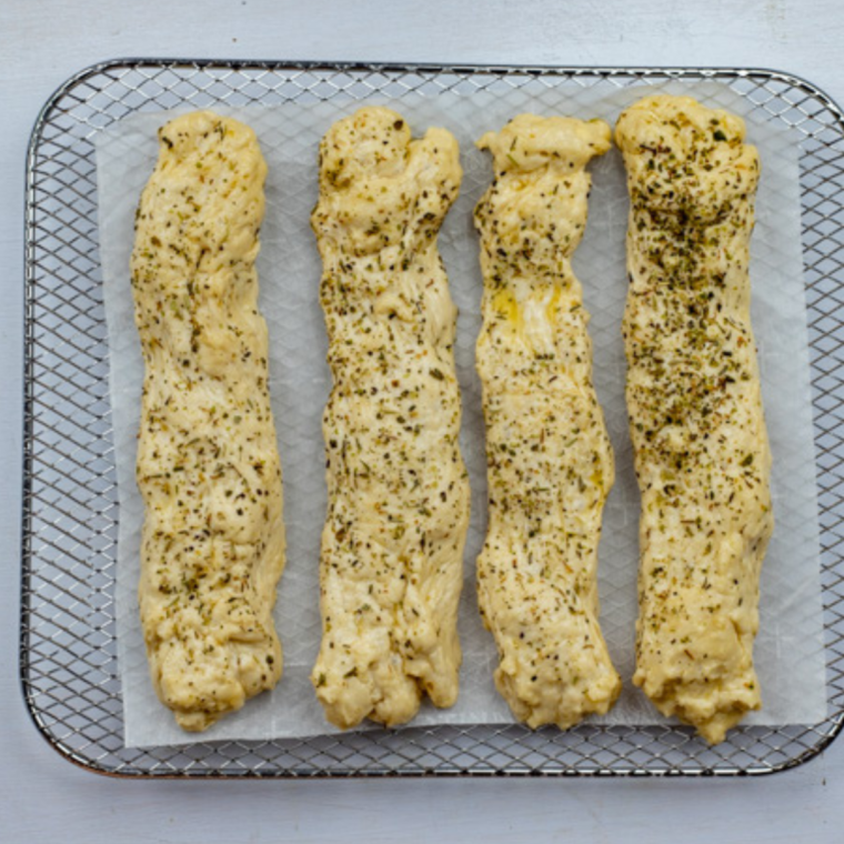 Golden Air Fryer Copycat Olive Garden Breadsticks brushed with butter and sprinkled with Italian seasoning.