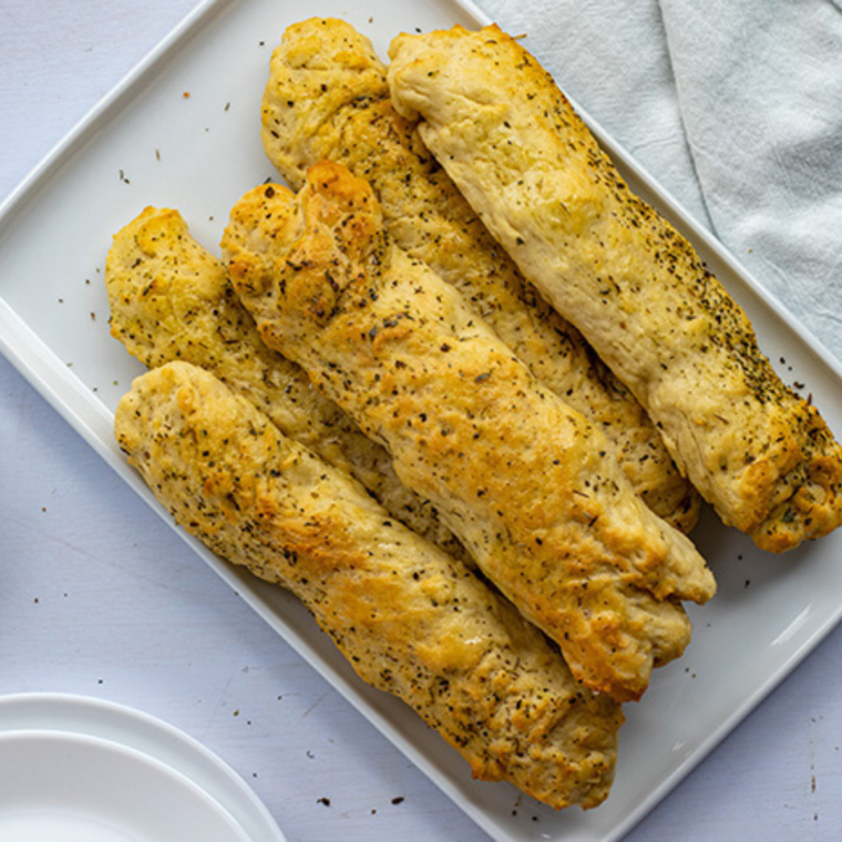 Golden, buttery breadsticks seasoned with Italian herbs, freshly cooked in the air fryer.