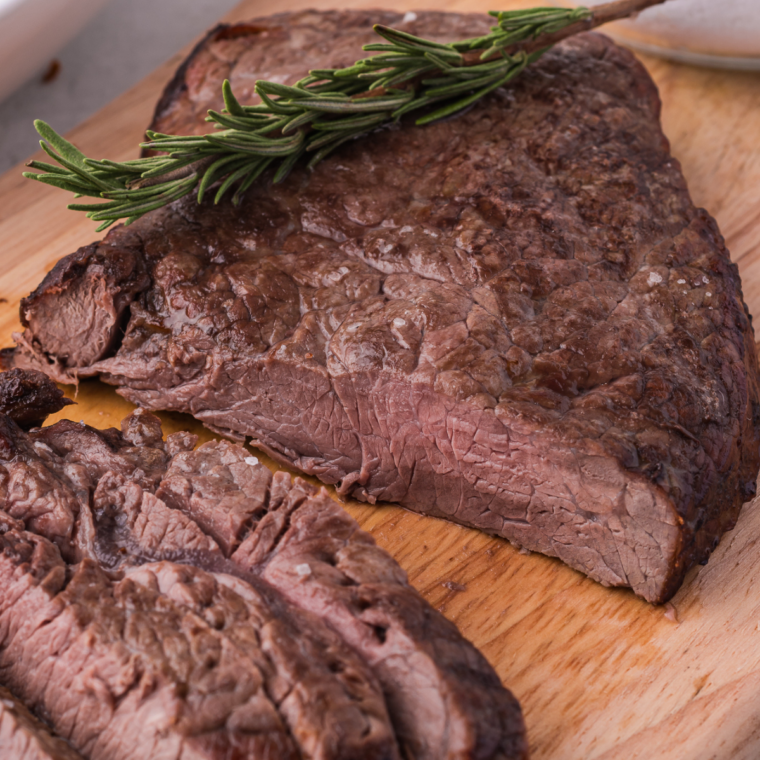 Juicy air fryer steaks topped with creamy homemade Boursin cheese melting over the warm surface before serving