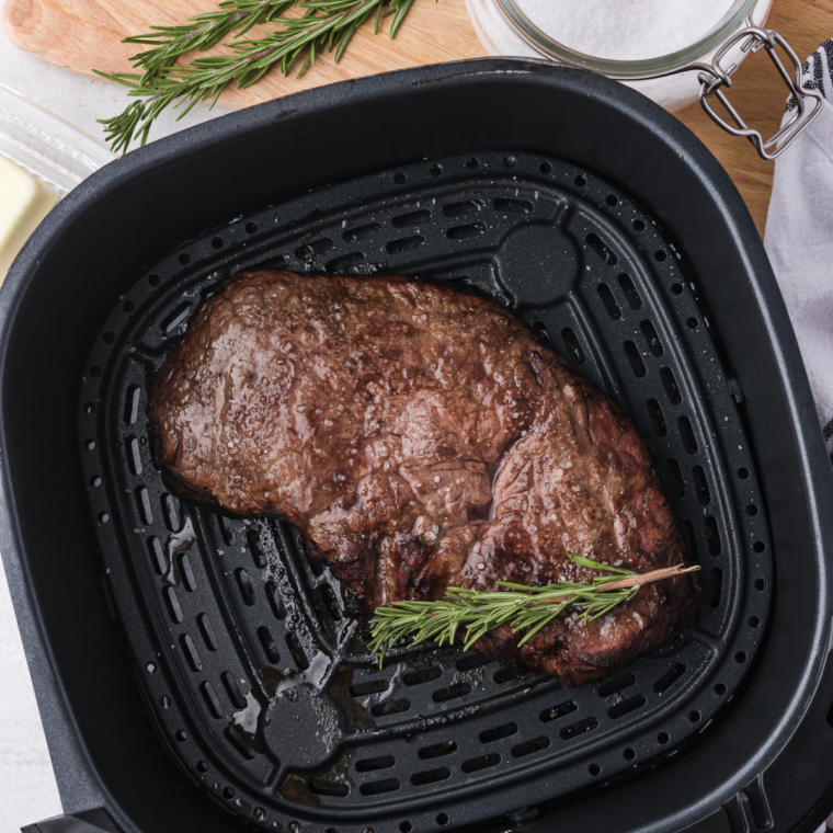 Cooked steaks resting on cutting board loosely covered with foil to lock in juices before serving