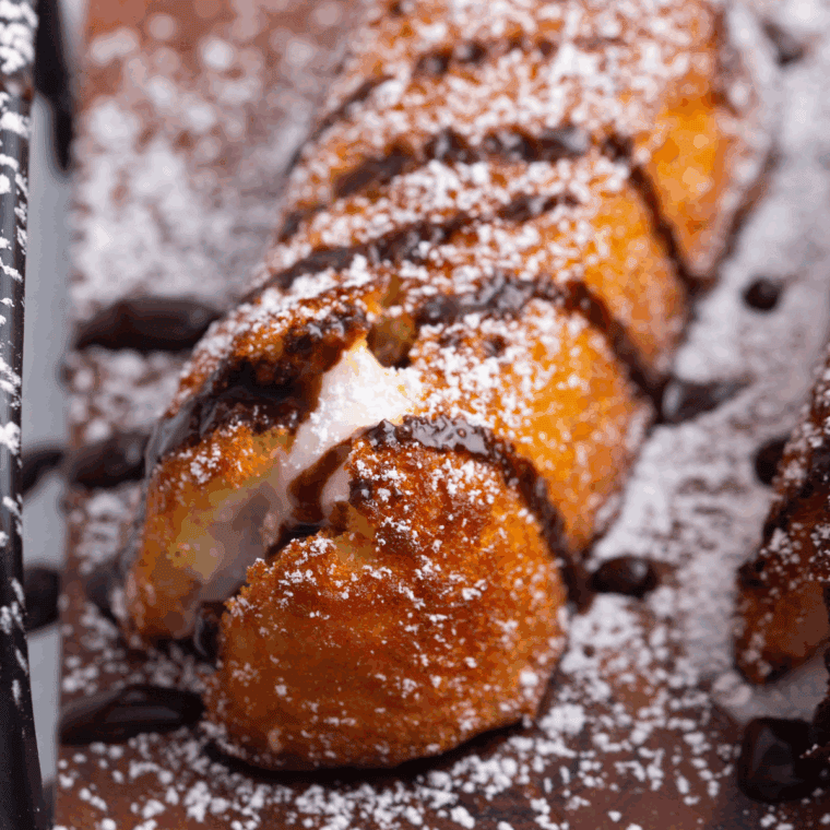 Crispy golden air fryer Twinkies on a plate, dusted with powdered sugar.
