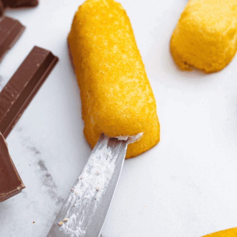 Cutting the twinkie with a slit, to add the candy bars.