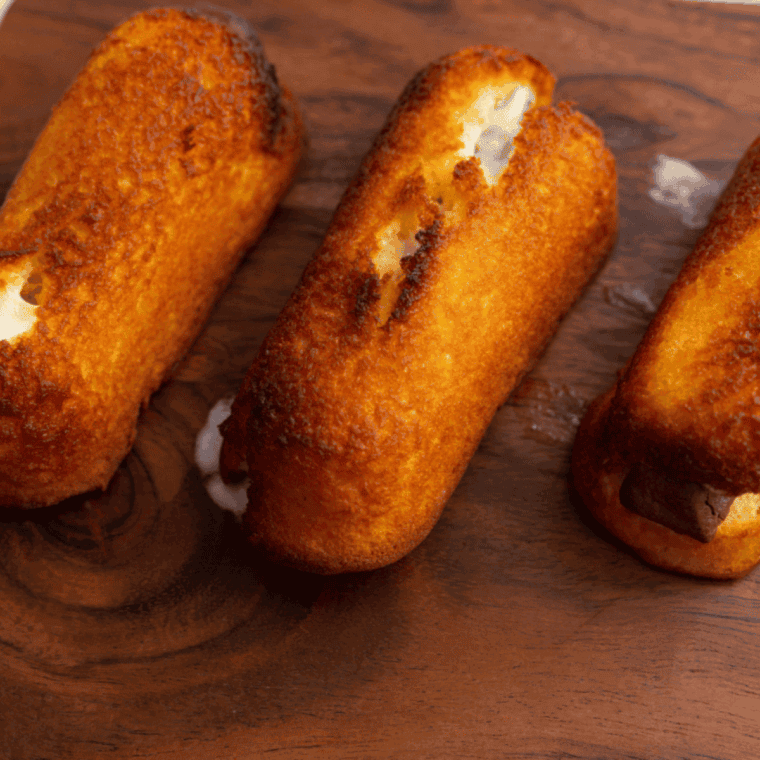 Cooked twinkies on cutting board.