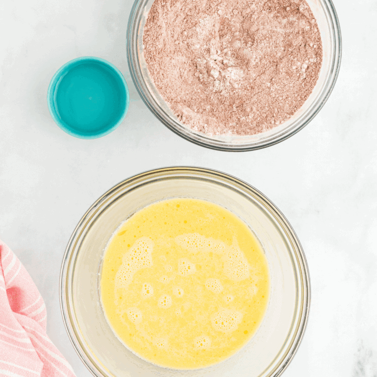 Mixing dry ingredients in a large bowl with flour, sugar, cocoa, baking powder, baking soda, and salt, while preparing a muffin tin with paper liners.