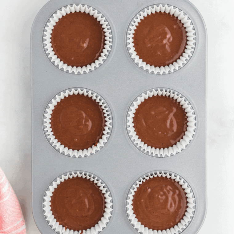 Folding wet ingredients into dry ingredients with a spatula, then gently mixing in semi-sweet chocolate chips, leaving a few to sprinkle on top.