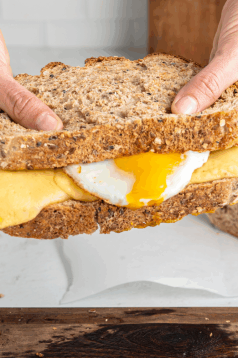 Golden, crispy air fryer breakfast grilled cheese sandwich with melted provolone and fried egg inside, ready to serve.