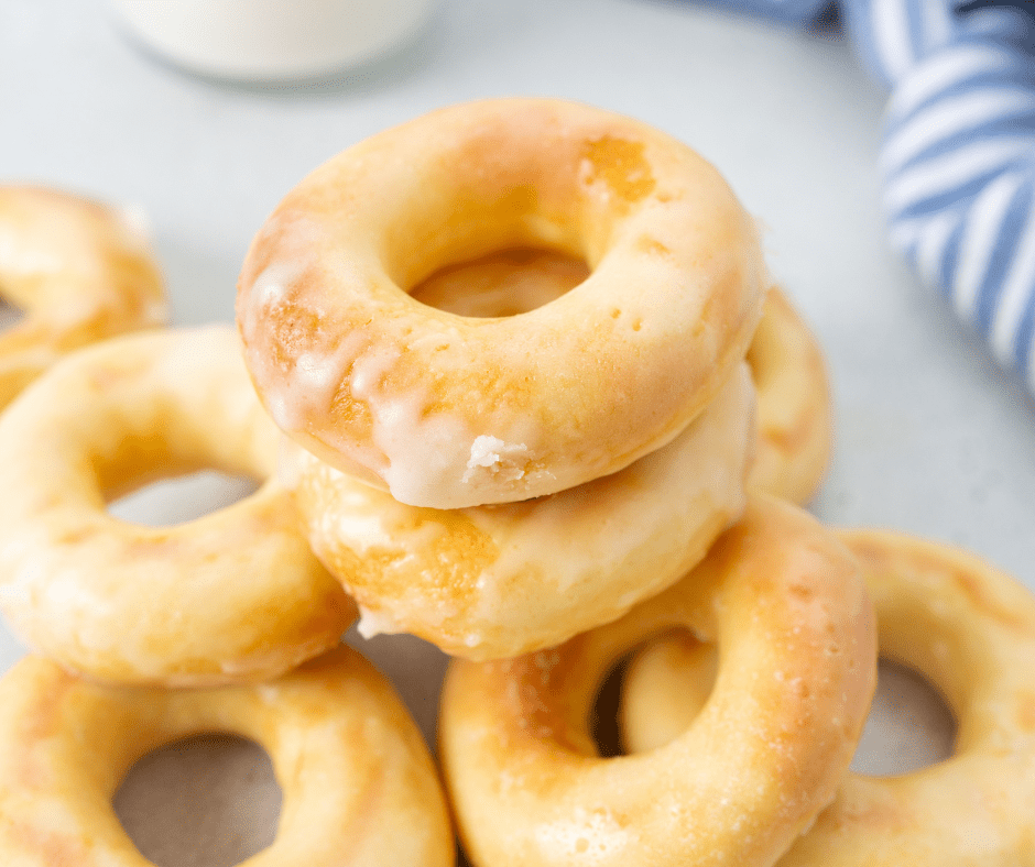 round glazed yeast donuts on a blue plate