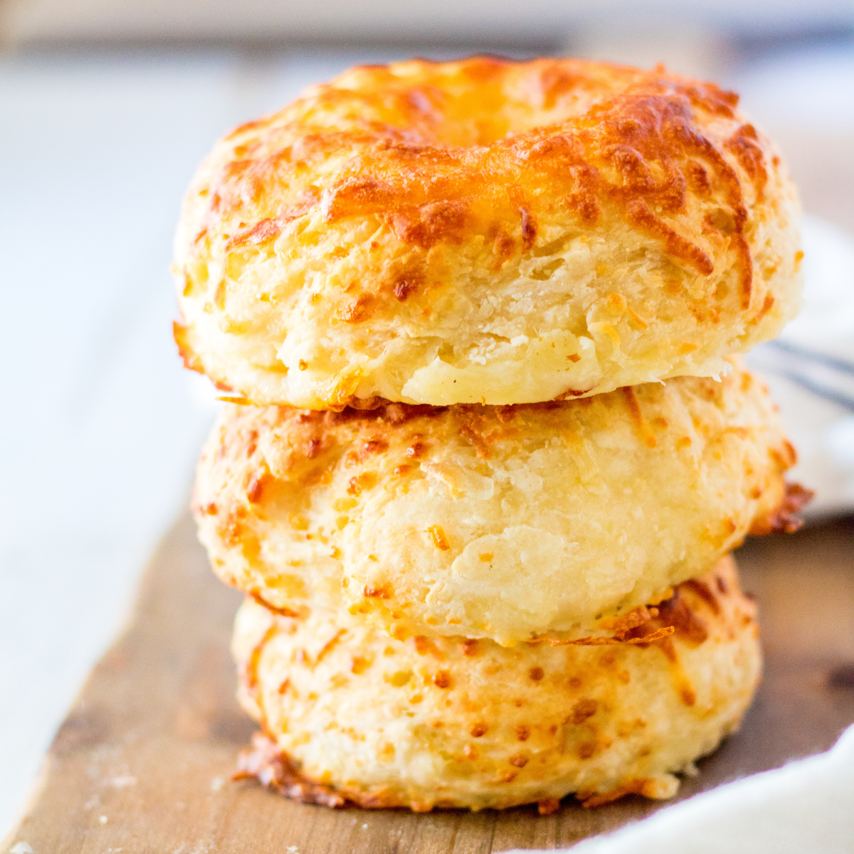 A stack of golden-brown Air Fryer Asiago Cheese Bagels with a crispy exterior and melted cheese on top.