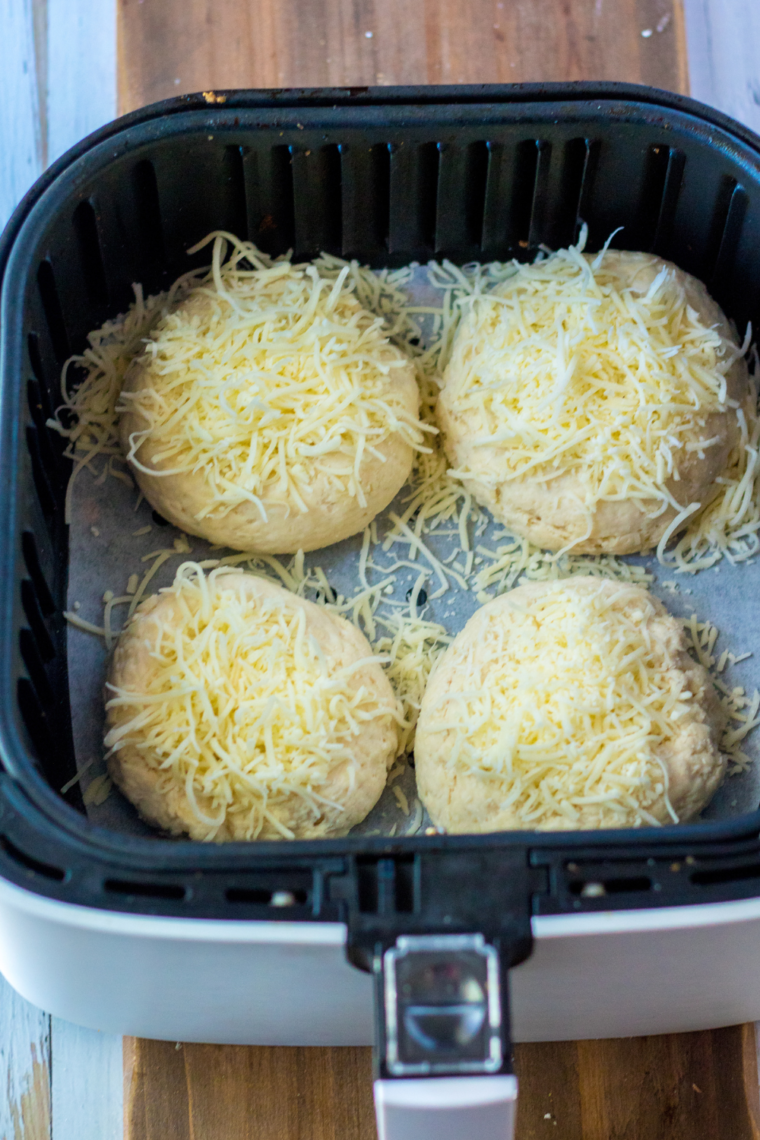 Close-up of Air Fryer Asiago cheese bagels in the air fryer basket.