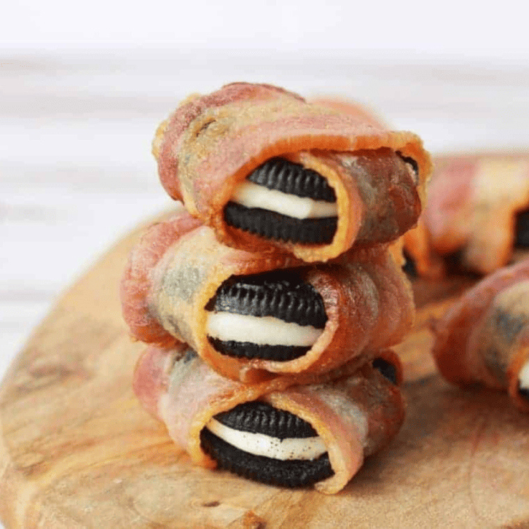 Golden-brown bacon-wrapped Oreos arranged on a plate, showcasing their crispy texture.