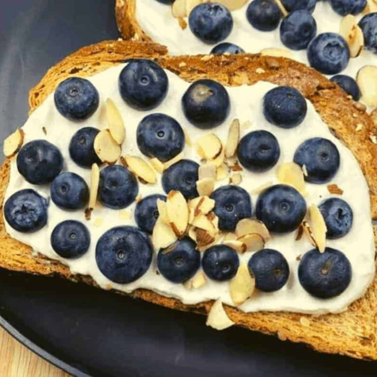 Close-up of Air Fryer Blueberry Honey Ricotta Toast topped with fresh blueberries and a drizzle of honey.