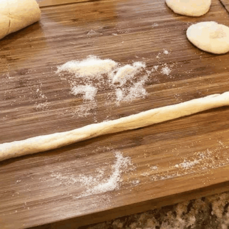 Rolling crescent dough into a braid, cutting into two portions, and shaping into a circle to form a pastry.