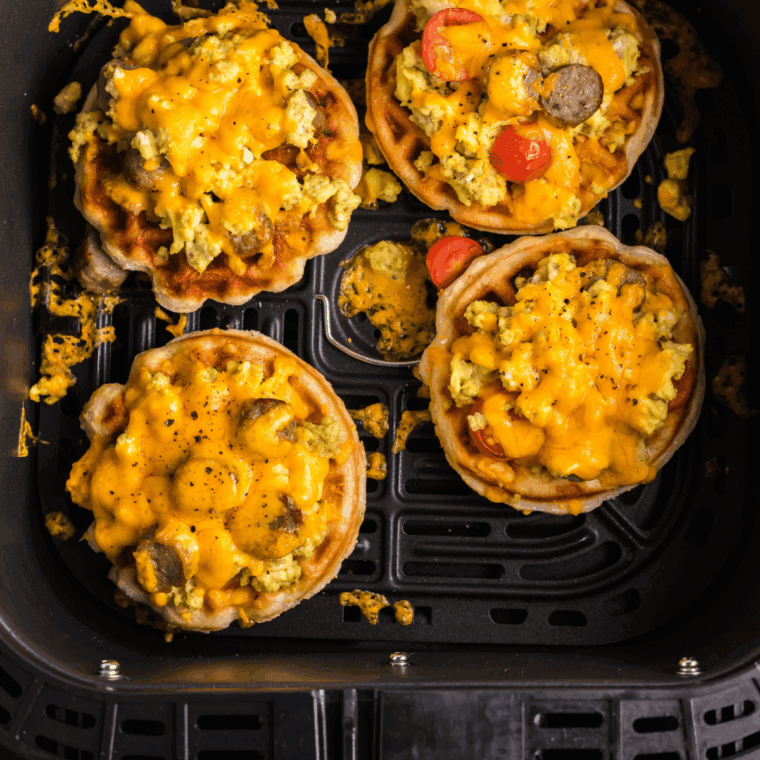 A fresh Air Fryer English Muffin Breakfast Pizza, topped with melted cheese, a fried egg, and savory toppings, ready to enjoy.
