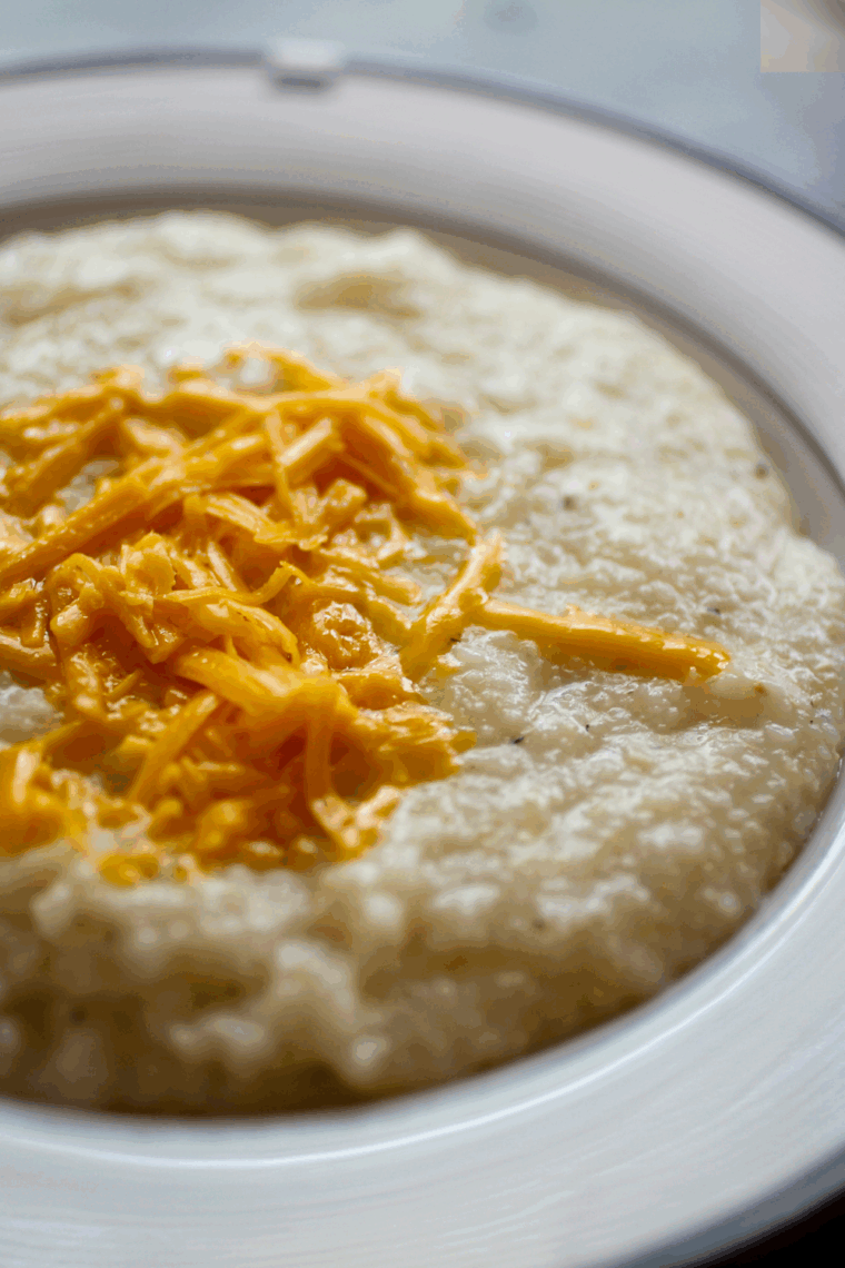large bowl of rich, creamy, and buttery Golden Corral grits topped with a pat of melting butter.