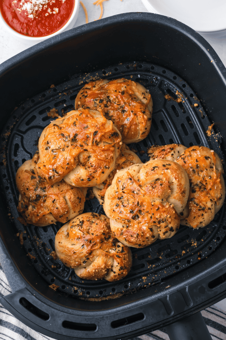 Golden-brown Trader Joe’s Air Fryer Garlic Cheddar Knots topped with melted cheese and garlic butter.