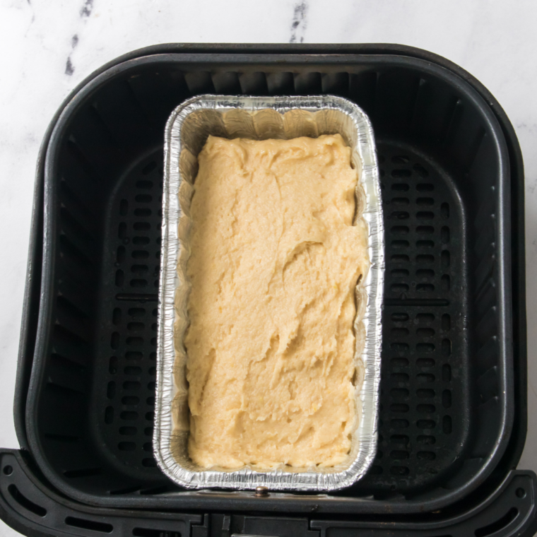 Blueberry bread batter divided among three greased mini loaf pans