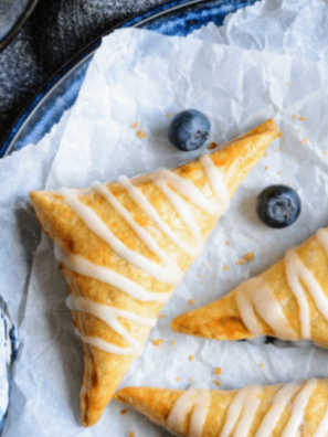 Golden, flaky blueberry turnovers cooked in the air fryer, served on a plate.