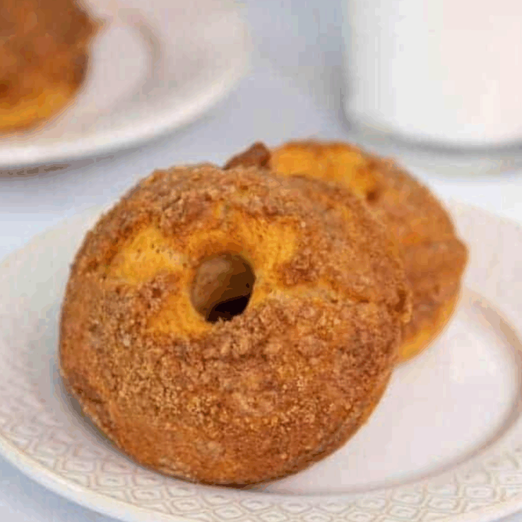 Freshly baked air fryer cinnamon crumb donuts, golden, fluffy, and topped with cinnamon crumbs.