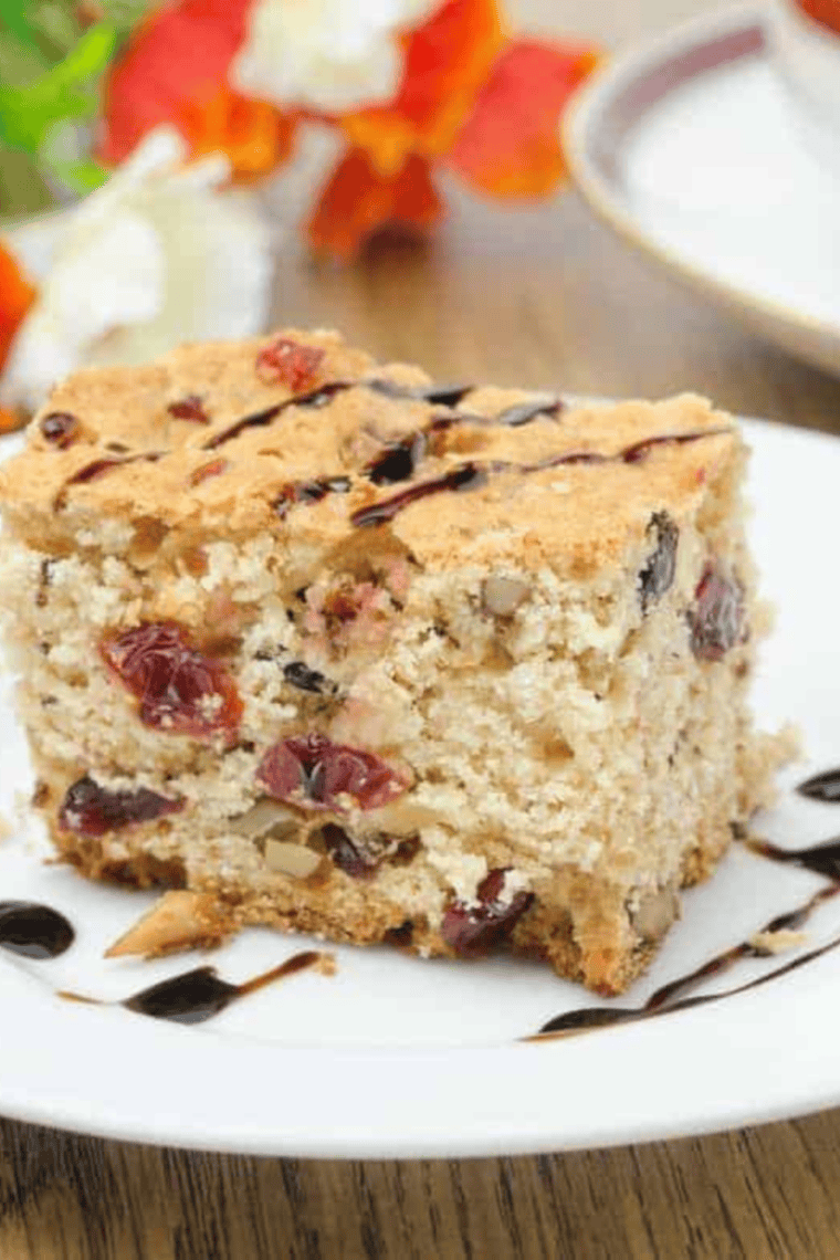 Golden-brown air fryer cranberry and walnut bundt cake with cranberries and walnuts on top, ready to serve.