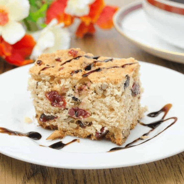 Golden brown Air Fryer Cranberry and Walnut Bundt Cake, sliced to reveal juicy cranberries and chopped walnuts inside.