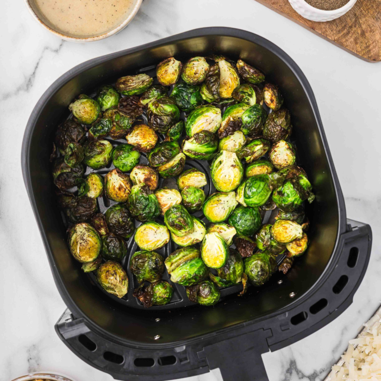 Cooked Air Fryer Lemon Pepper Brussels Sprouts in air fryer basket.