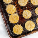 Crispy air fryer summer squash slices on a white plate garnished with fresh parsley