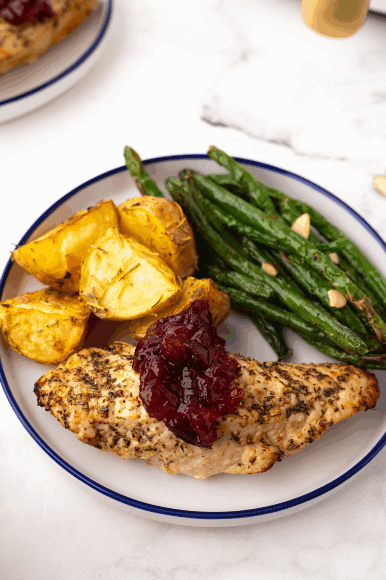 Crispy golden Boston Market-style garlic dill potato wedges served on a white plate with fresh herbs.