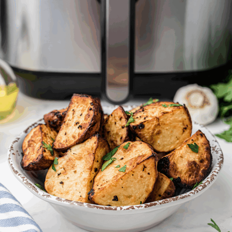 Golden, crispy Boston Market-style garlic dill potato wedges served on a white plate with a side of dipping sauce.