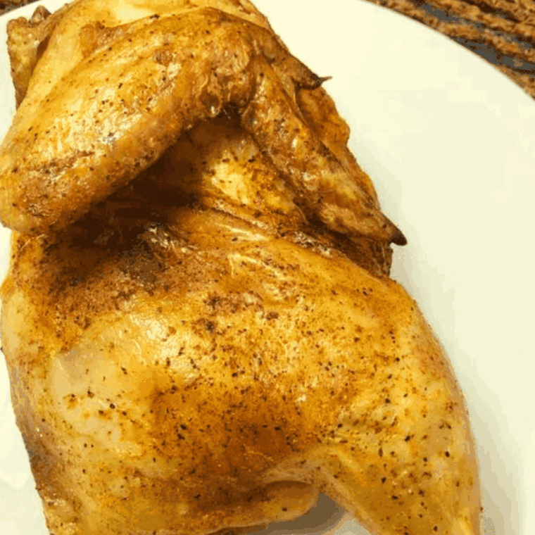 Crispy herb roasted chicken served on a plate, ready to eat.