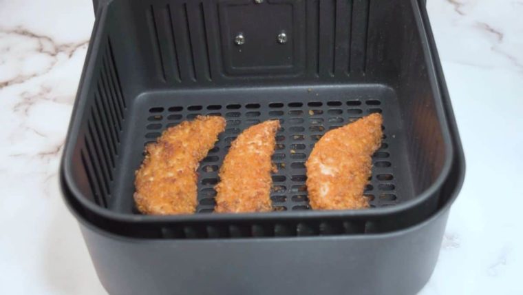 3 doritos chicken tenders in an air fryer basket