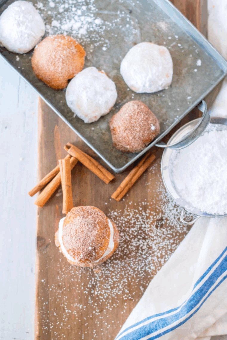 Close-up of golden air fryer donut holes generously coated with powdered sugar.