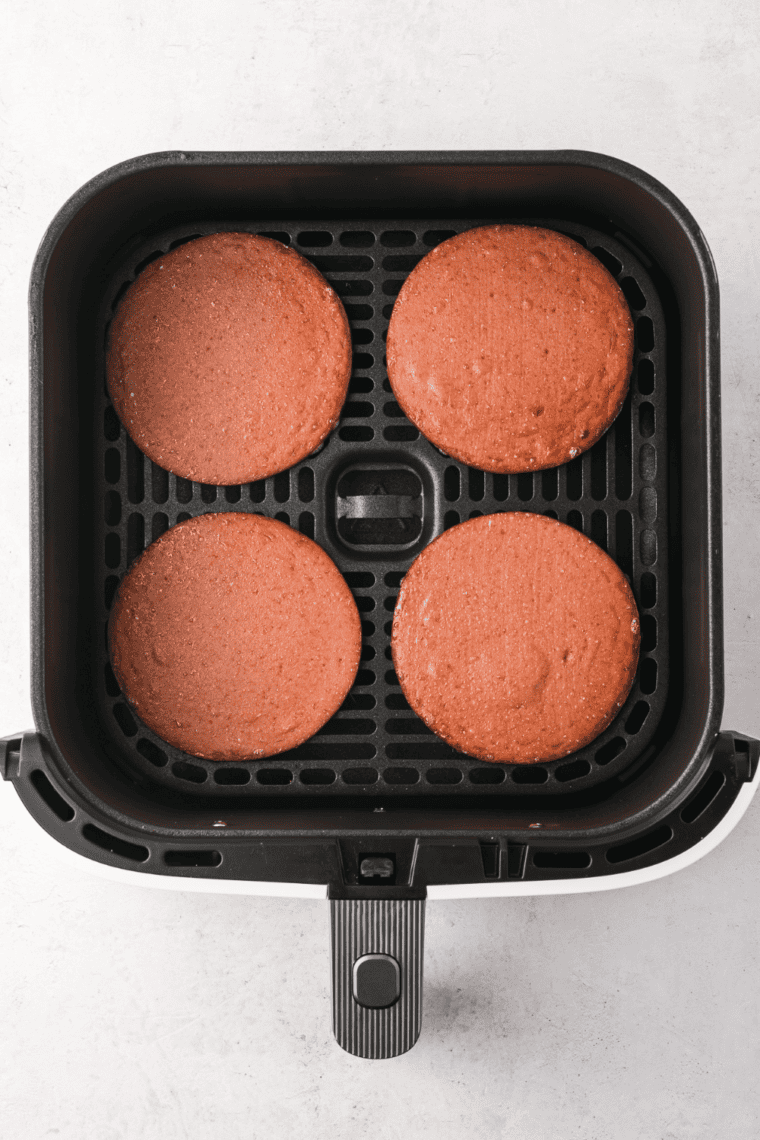 Crispy fried bologna slices in an air fryer basket, golden and ready to serve.