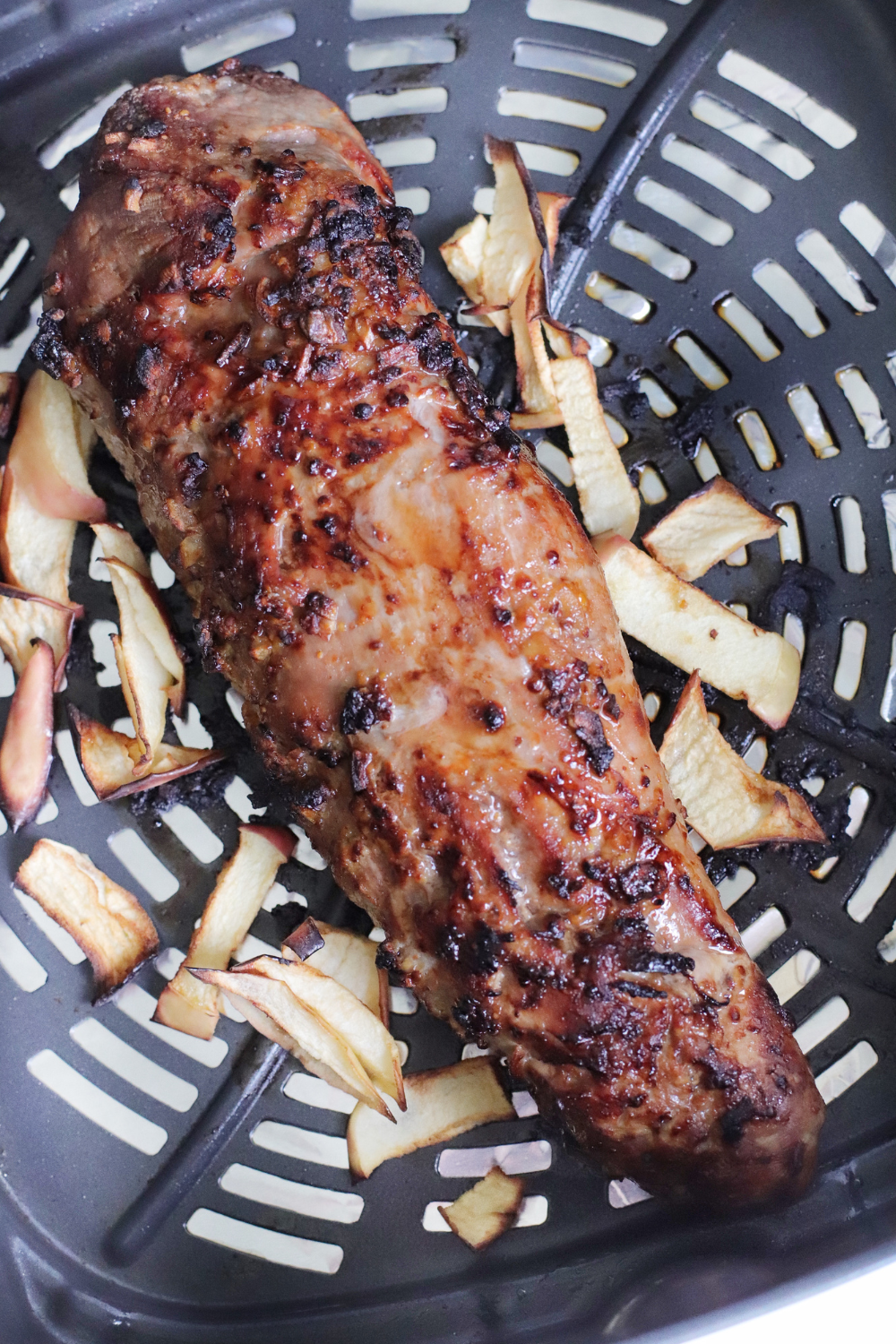 A beautifully plated pork tenderloin drizzled with caramelized barbecue sauce, garnished with fresh herbs, showcasing a juicy and flavorful dish.