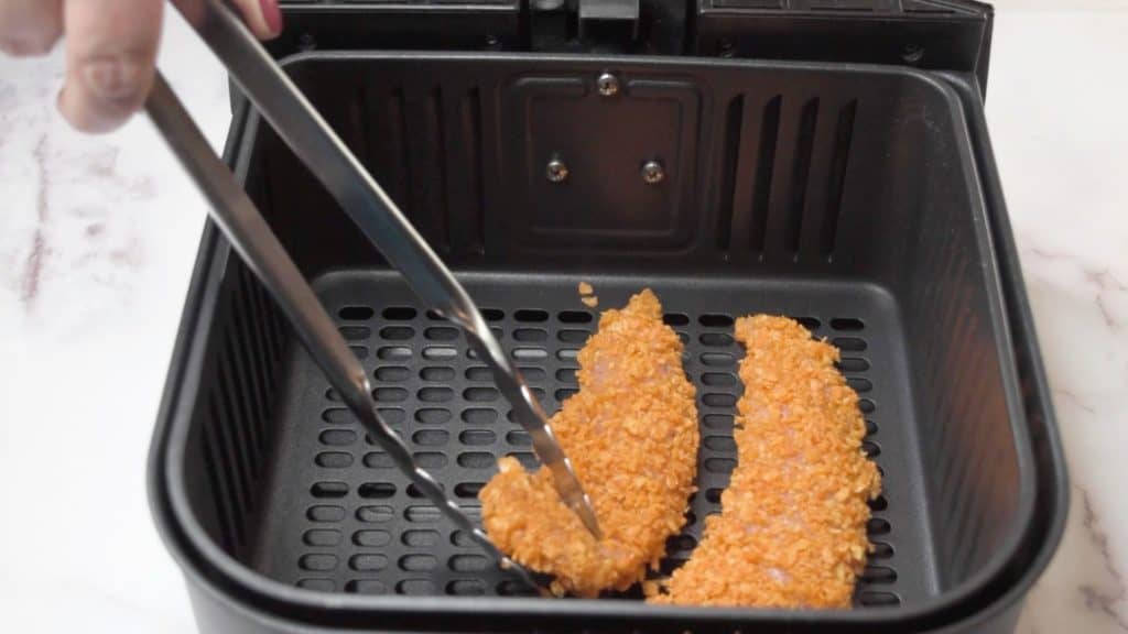Place the coated chicken tenders on a greased air fryer tray or in the greased air fryer basket.