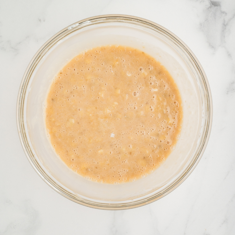 Mixing flour, baking soda, salt, and cinnamon in a bowl for banana nut bread base.