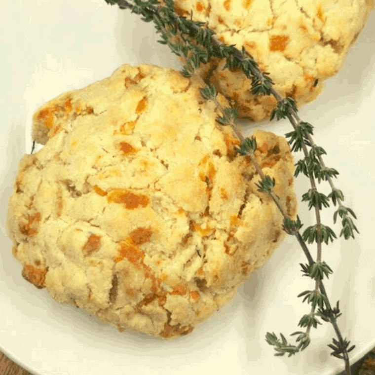 Air fryer cheddar thyme flaky biscuits with golden crust and melted cheese.