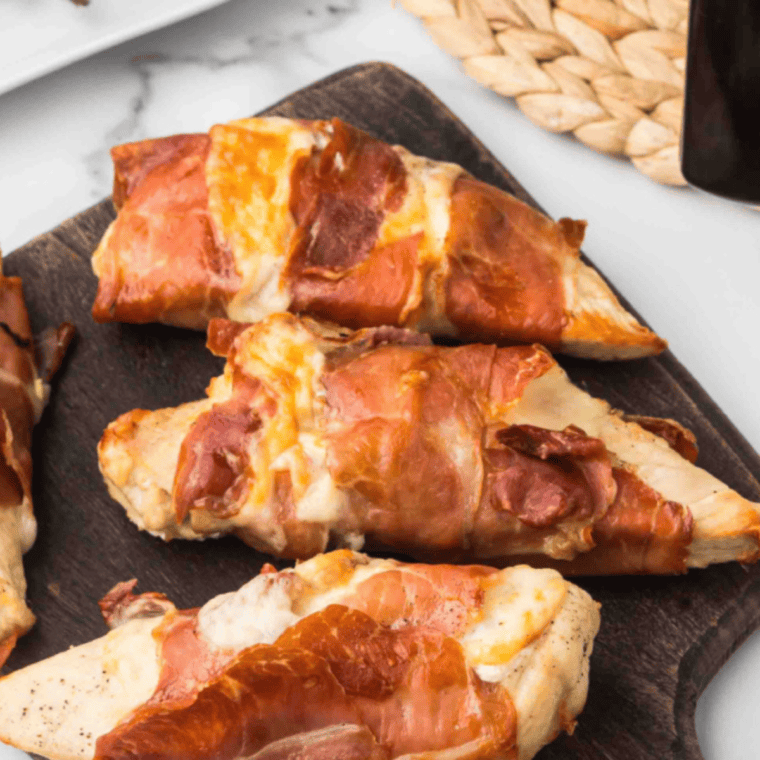 Air-fried chicken saltimbocca wrapped in prosciutto with sage, served golden brown with asparagus and shallots