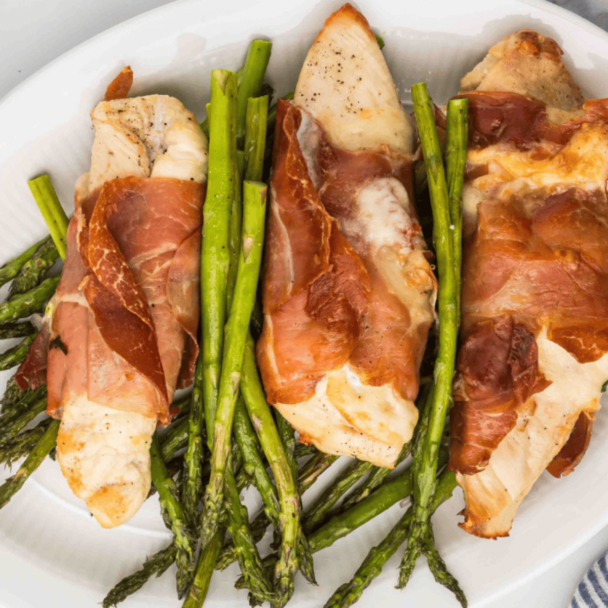 Golden air fryer chicken cutlets wrapped in prosciutto and topped with sage leaves, served with lemon slices