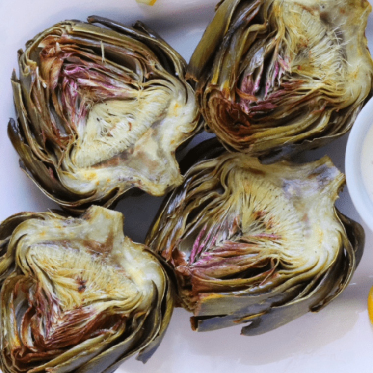 Halved air fryer roasted artichokes showing the tender, juicy interior.