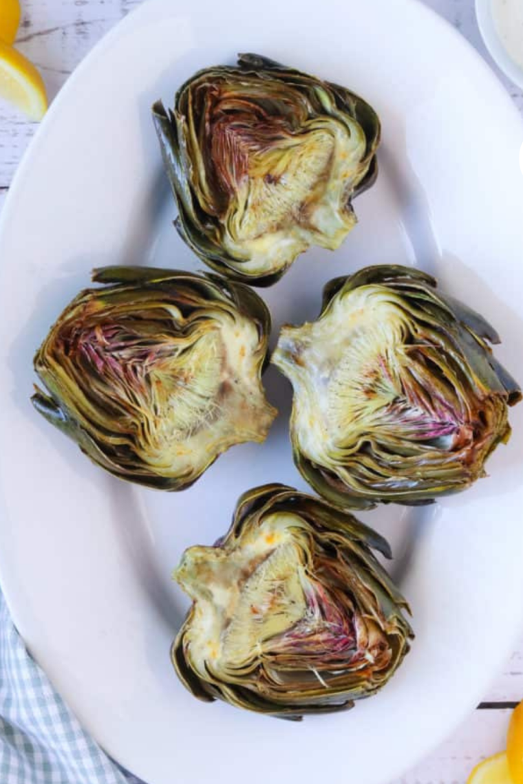 Golden brown, perfectly roasted artichokes ready to be served on a plate.